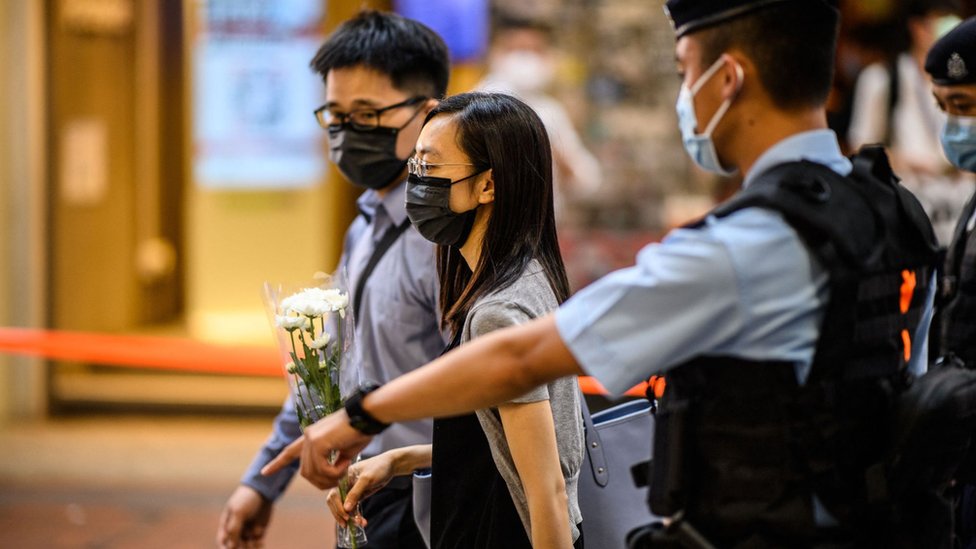 香港銅鑼灣崇光百貨公司外警員驅離一對手持白菊花的男女（2/7/2021）