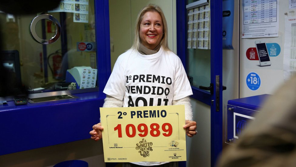 Сотрудник лотереи в Мадриде празднует продажу номера 10989, который получил второй приз в розыгрыше лотереи в Мадриде.