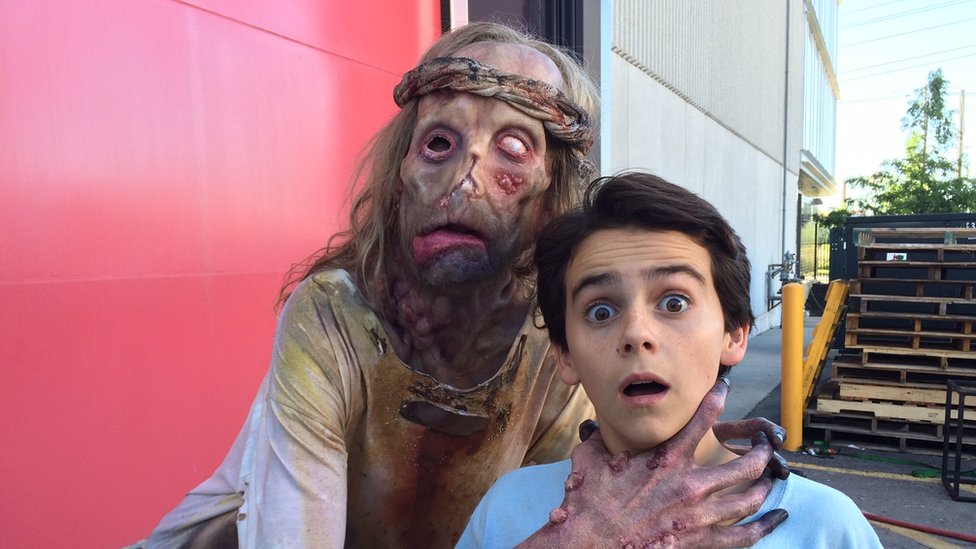 Javier fake-choking one of the children on set of It while in leper costume