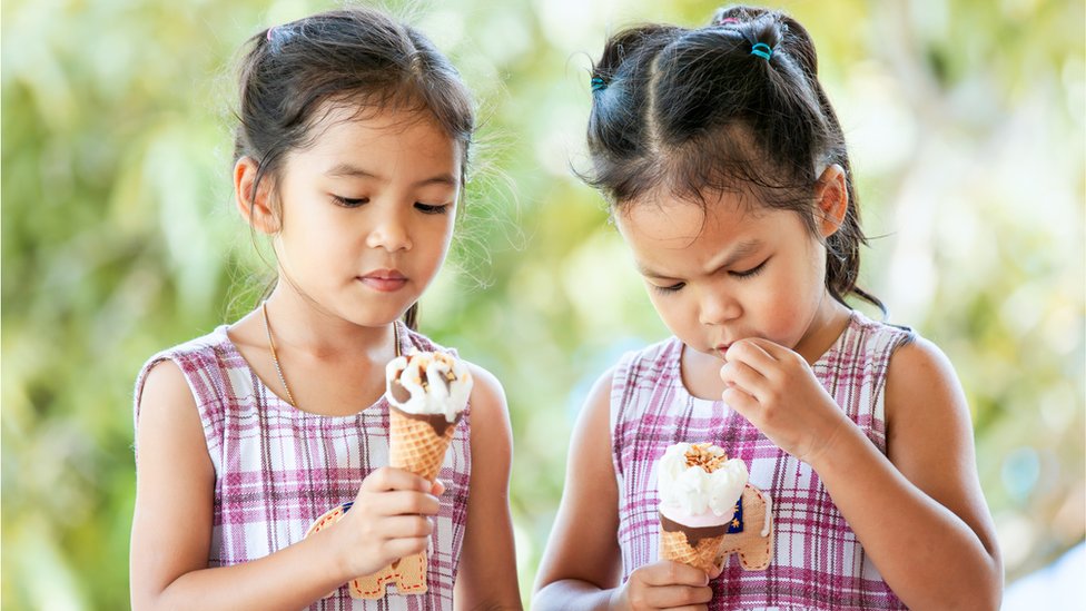 Identical twins eating ice cream