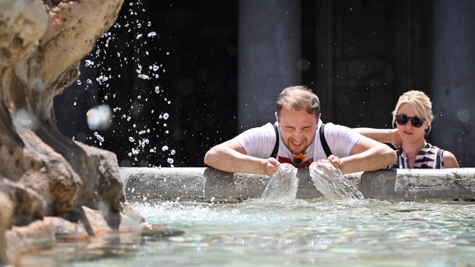 Hombre se refresca en una fuente en Roma.