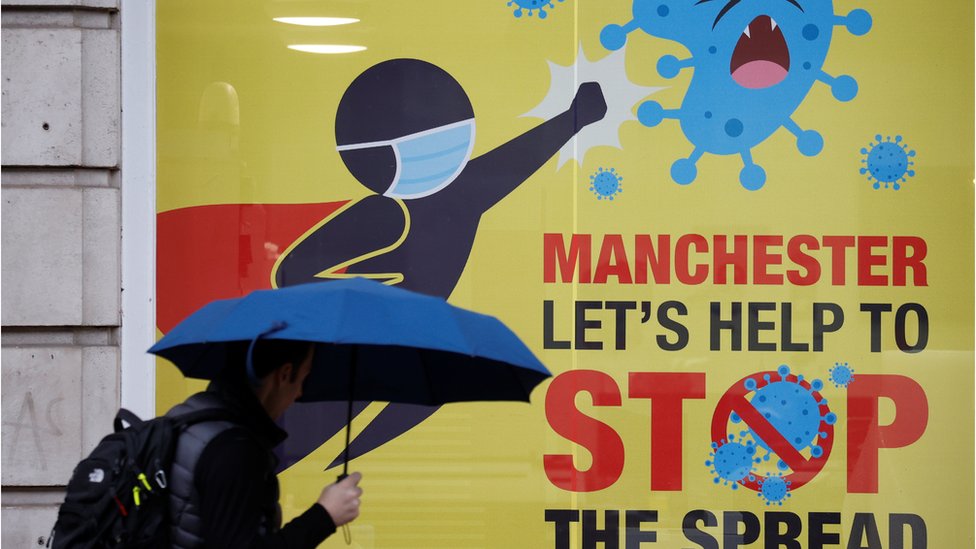 A man walks past a poster amid the outbreak of the coronavirus disease