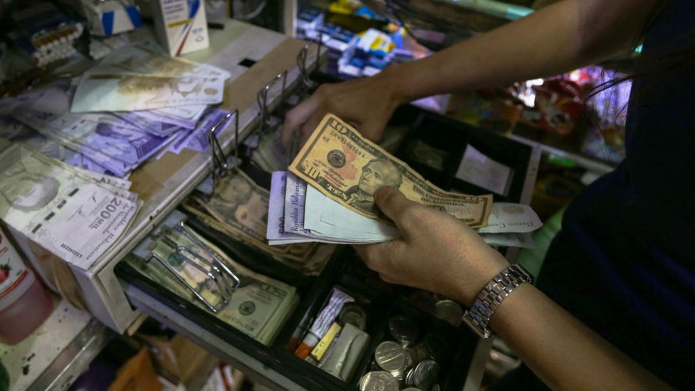 En un negocio en Venezuela guardan billetes de dólares en una caja registradora.
