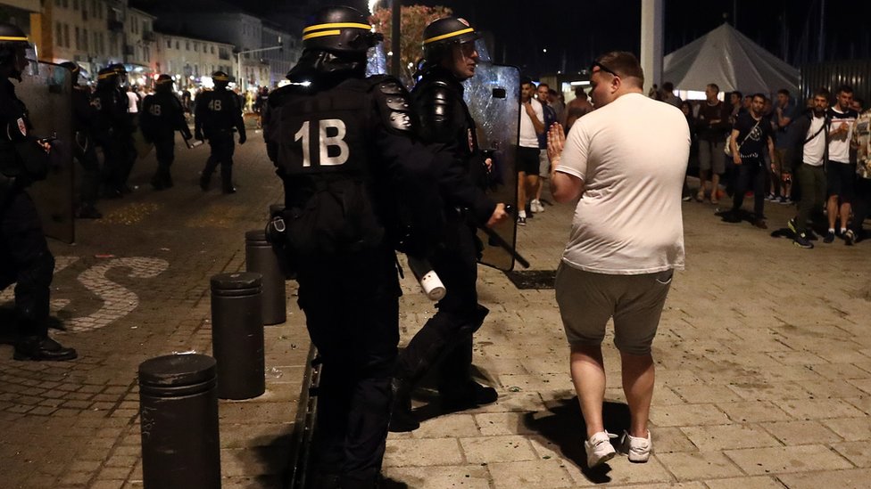 An England football fan scuffles with a police officer in Marseille