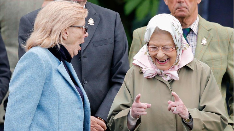 The Queen gesturing how close a horse race was to a fellow spectator