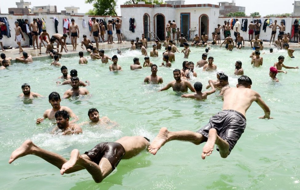 Индийская молодежь играет в бассейне в жаркий летний день на окраине Амритсара 2 июня 2019 года.