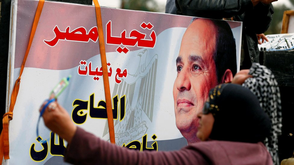 سيدة ترفع لافتة مؤيدة للسيسي