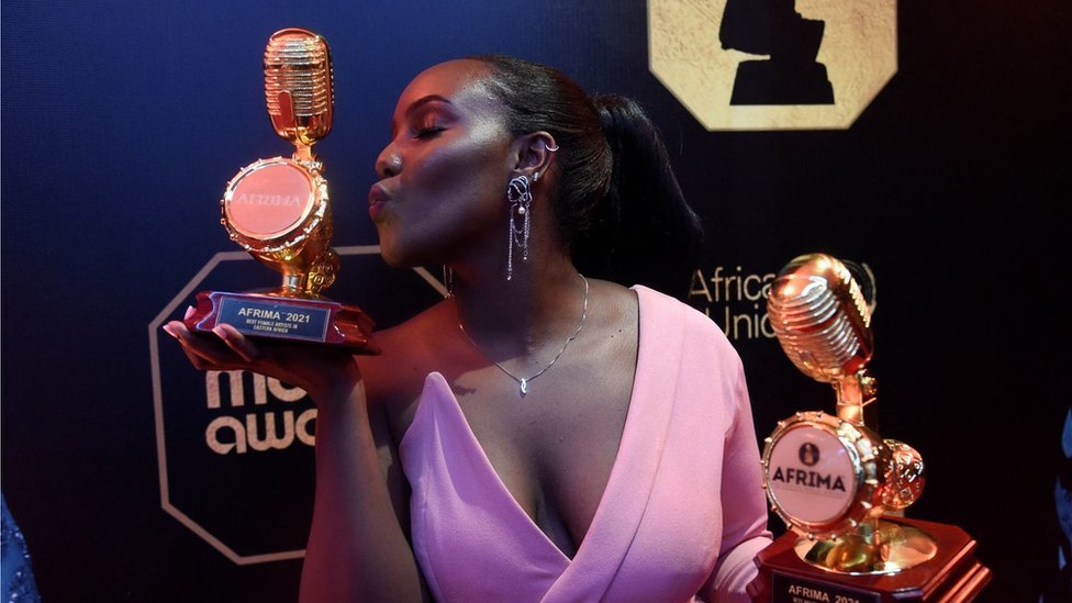 المغنية الكينية نيكيتا كيرينغ، الحائزة على جائزتين خلال الحفل في لاغوس تمسك بجائزة وتقبل أخرى