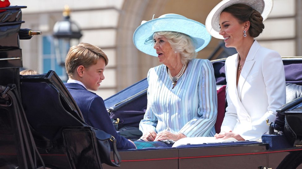 El príncipe George, la duquesa de Cornualles y la duquesa de Cambridge (derecha) en un carruaje tirado por caballos.