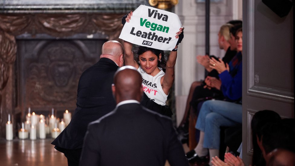 Peta aktivistkinja koja nosi majicu sa porukom "životinje nisu materijal" i znak "živela veganska koža" na Nedelji mode u Parizu