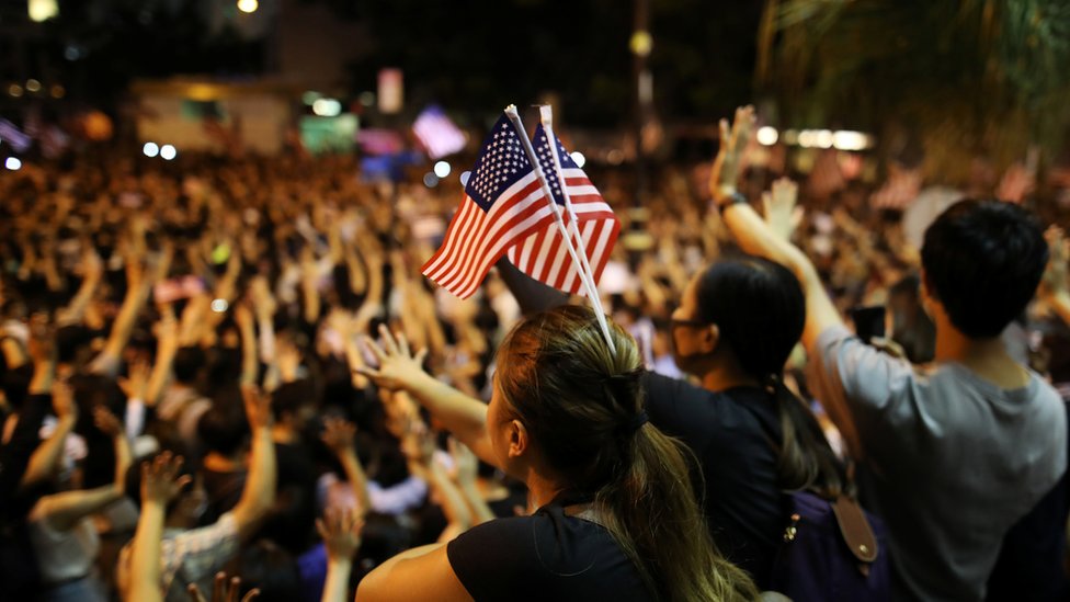 支持法案的示威者舉行集會，期間多人揮舞美國國旗。