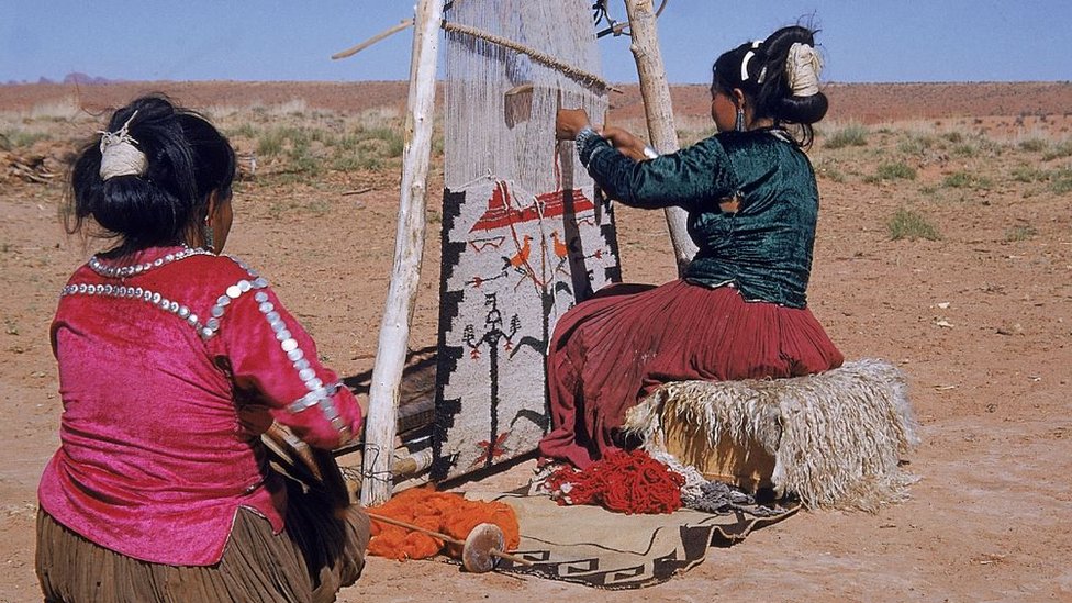 Dos mujeres navajo usan un telar para tejer en Monument Valley, Arizona