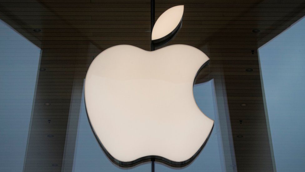 На этой фотографии изображен логотип Apple, прикрученный к стеклянному фасаду магазина в Нью-Йорке