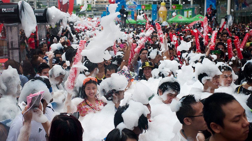 Гуляки принимают участие в водном бою во время фестиваля воды Сонгкран на Силом-роуд 13 апреля 2015 года в Бангкоке, Таиланд.