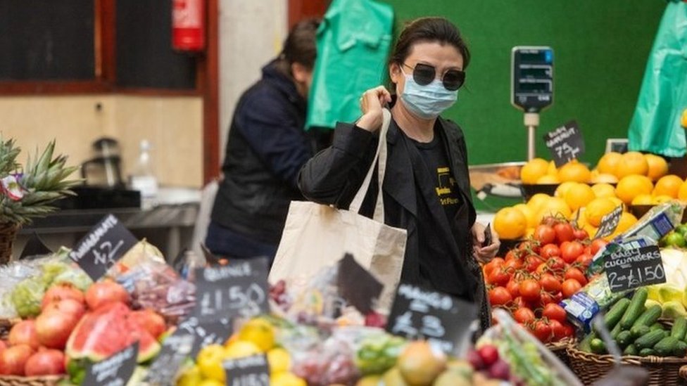 Seorang pengunjung mengenakan masker di Borough Market, London