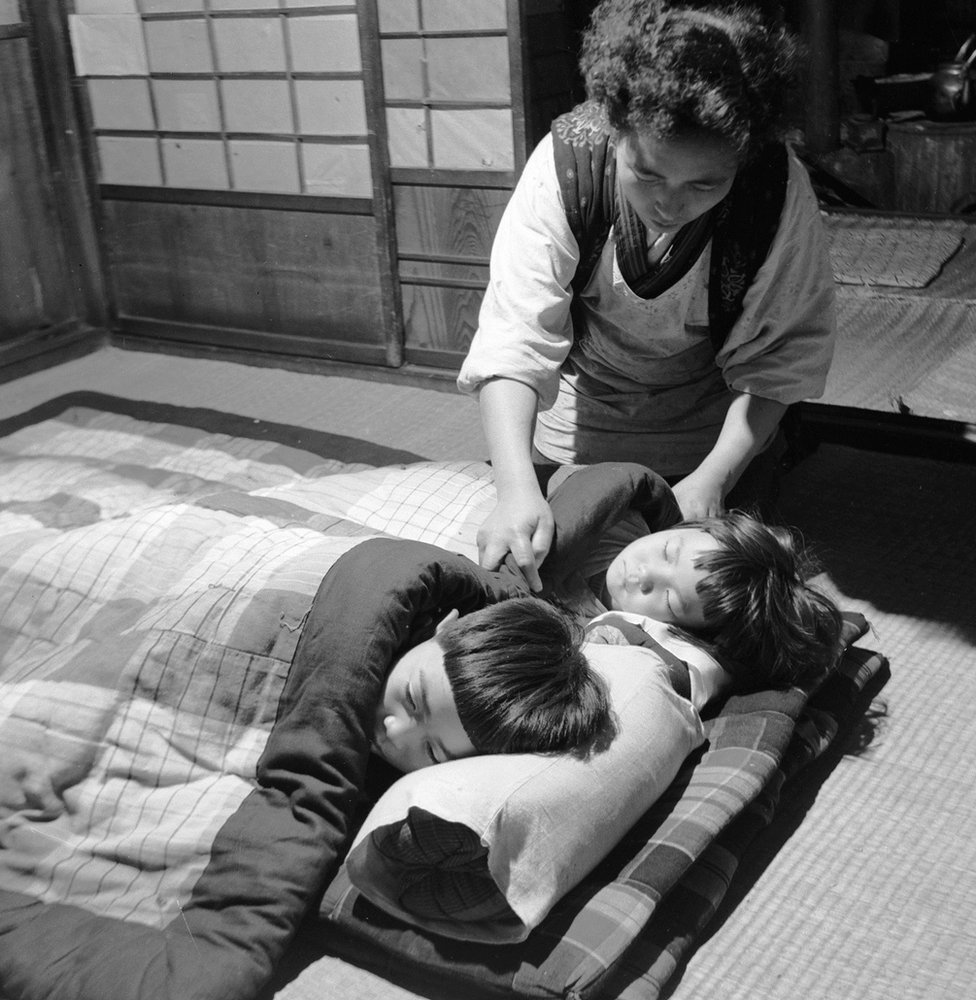 Дети, уставшие от празднования Дня Благодарения или Нийнэ-сай в Японии, укладываются на свои кровати из циновок татами на полу. (Фото Орландо / Getty Images)