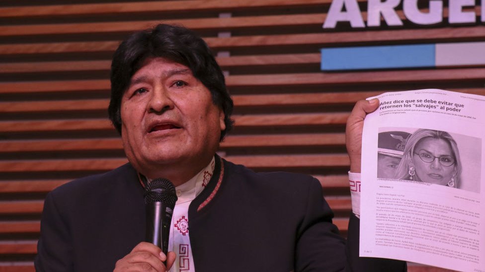 Evo Morales sosteniendo un artículo con una foto de Jeanine Áñez.