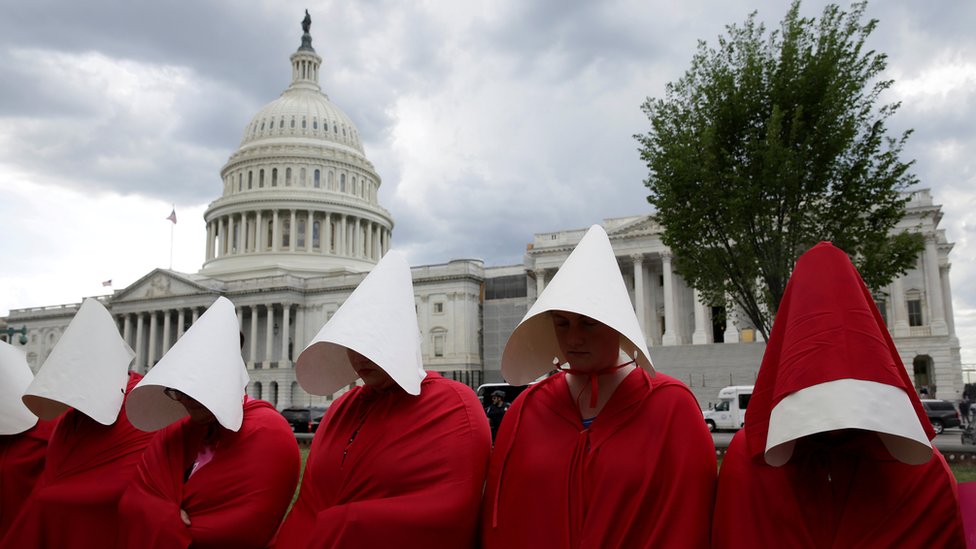 Un grupo de mujeres se vistió como los personajes de la serie "El cuento de la criada" para protestar contra los recortes al sector de la planificación familiar en Estados Unidos. Grupo de mujeres vestidas como las protagonistas de "EL cuento de la criada"