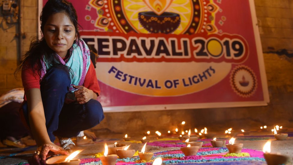 Женщина освещает лампы Дивали