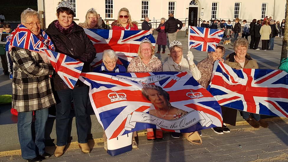 Поклонники королевы носят флаги Союза на Эбрингтон-сквер в Лондондерри