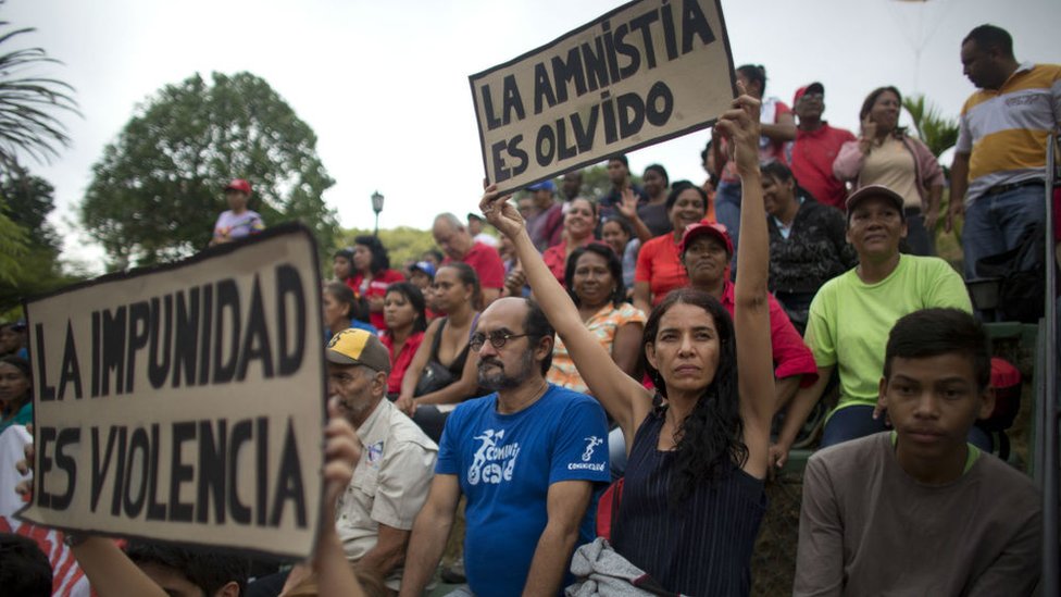 Сторонники президента Мадуро держат табличку с надписью «Амнистия - это забыть». 7 апр 2016