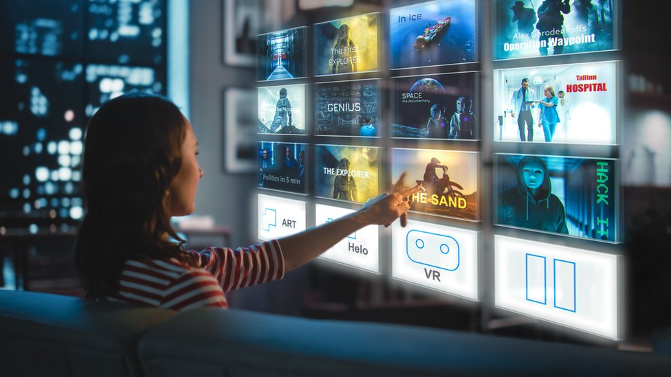 Una mujer selecciona programas en una pantalla virtual de TV