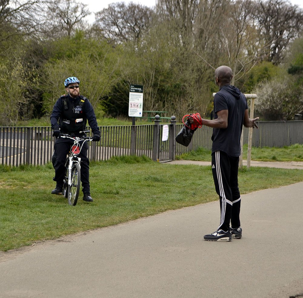 Полицейский разговаривает с человеком в парке
