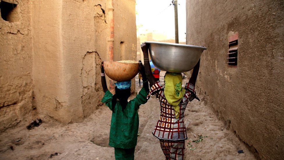 فتاتان نسيران في مدينة ديجينيه في مالي.
