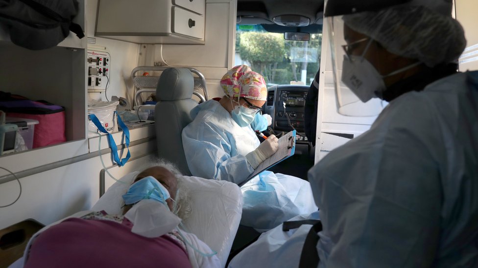 Медсестра заполняет бланк от имени пожилого пациента в машине скорой помощи в Сан-Паулу, Бразилия (2 июля 2020 г.)