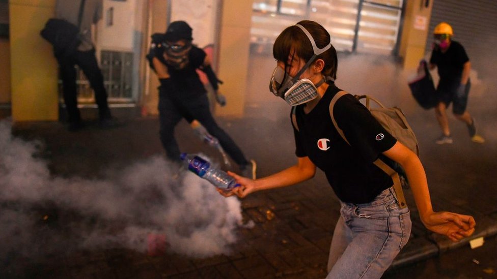 香港九龍深水埗一名女示威者躲避防暴警員發射的催淚彈（14/8/2019）