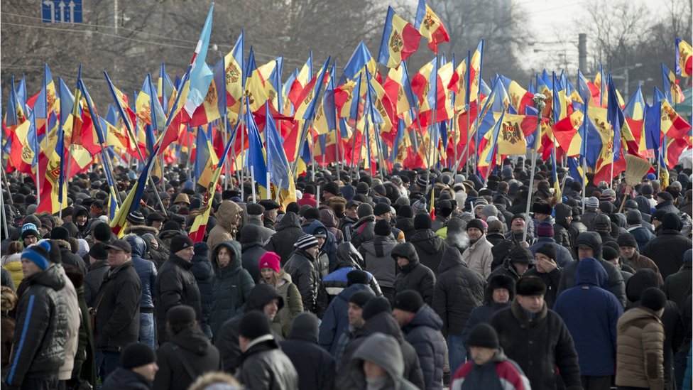 Люди держат флаги во время акции протеста в Кишиневе, Молдова, воскресенье, 24 января 2016 г.