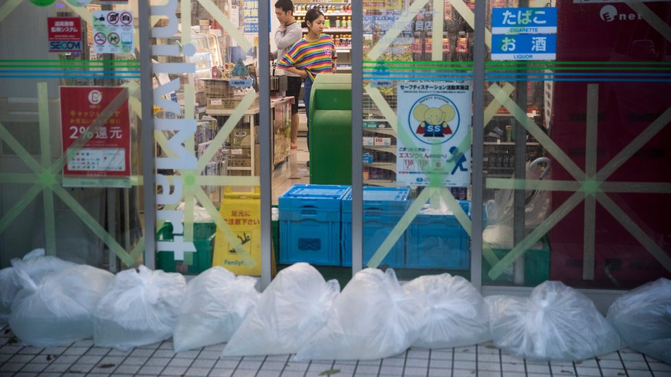 В магазине в Токио заклеены окна и пакеты с водой у входа в рамках подготовки к тайфуну Хагибис 12 октября.