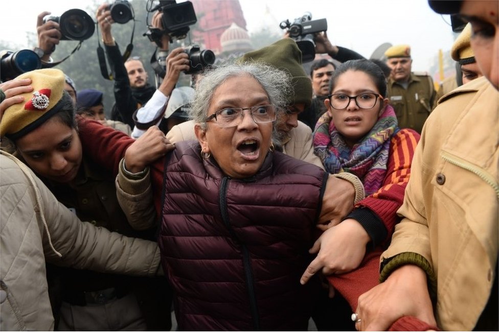 Женщина реагирует, когда она противостоит полиции на демонстрации против нового закона Индии о гражданстве в Нью-Дели 19 декабря 2019 года
