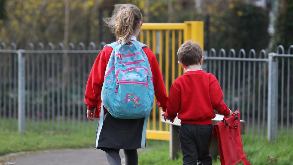 Two school children walking hand-in-hand