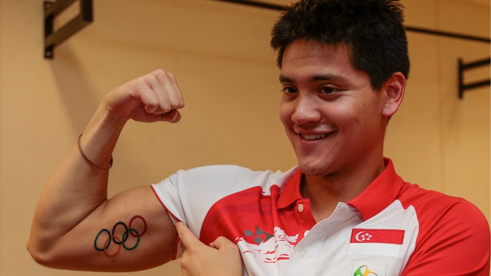 Золотой призер Олимпийских игр Джозеф Скучинг из Сингапура демонстрирует свежую татуировку с изображением олимпийского логотипа в Водном центре OCBC в Сингапуре, 16 августа 2016 г.