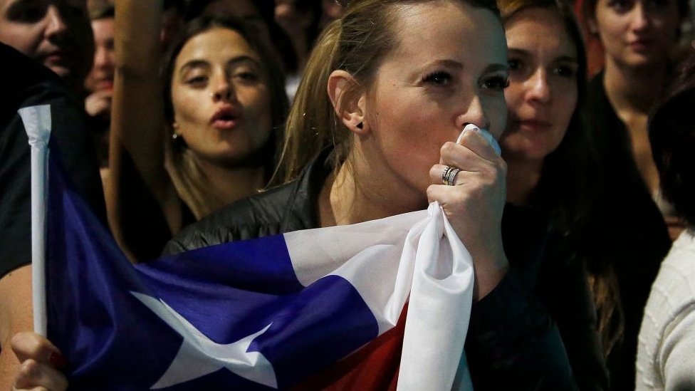 Mulher beijando a bandeira do Chile