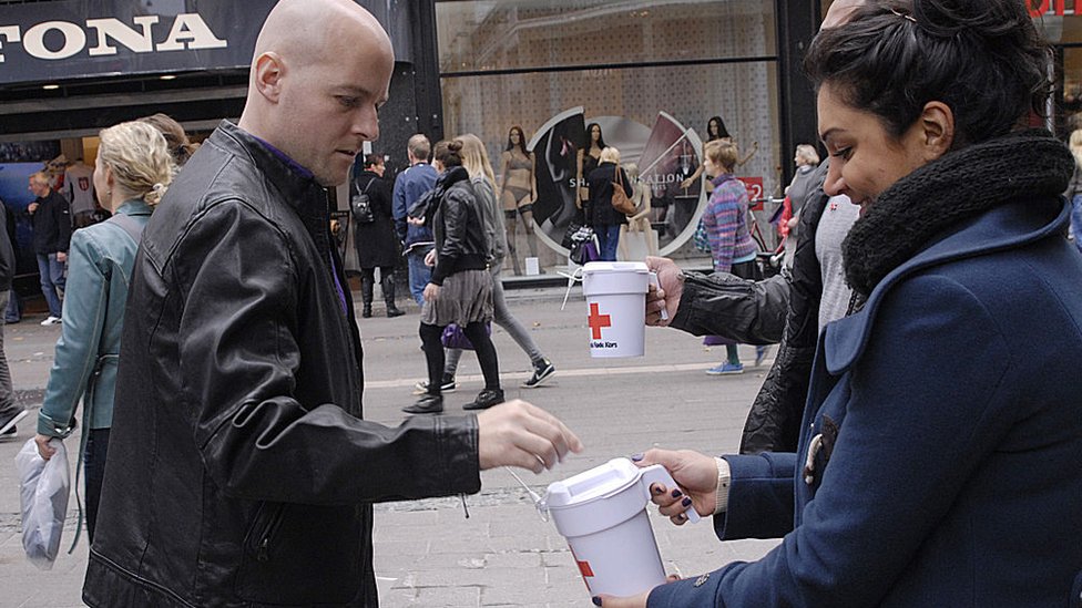 Personas recogiendo donaciones para la cruz roja danesa.