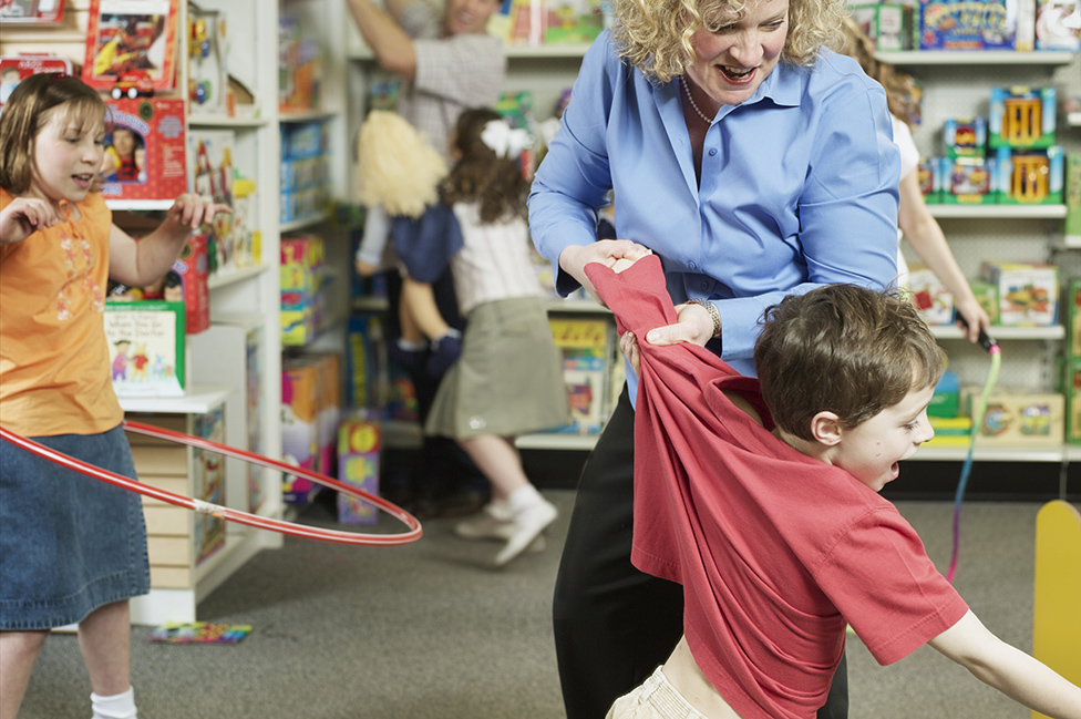 A mother tries to grab a child in a bookstore