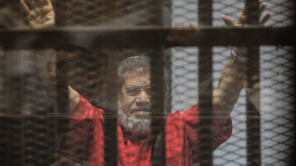Свергнутый президент Египта Мохамед Мурси жестикулирует во время судебного заседания по обвинению в шпионаже в Каире, Египет, 18 июня 2016 г.