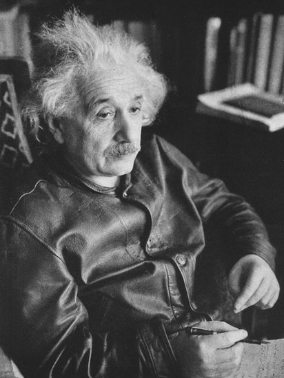 Einstein con su clásica chaqueta de cuero y su cabello despeinado.