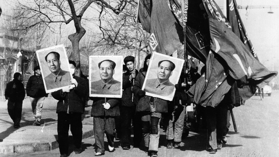 يحمل أعضاء الحرس الأحمر صوراً كبيرة لماو تسي تونغ أثناء مسيرة في شوارع بكين ، 1967