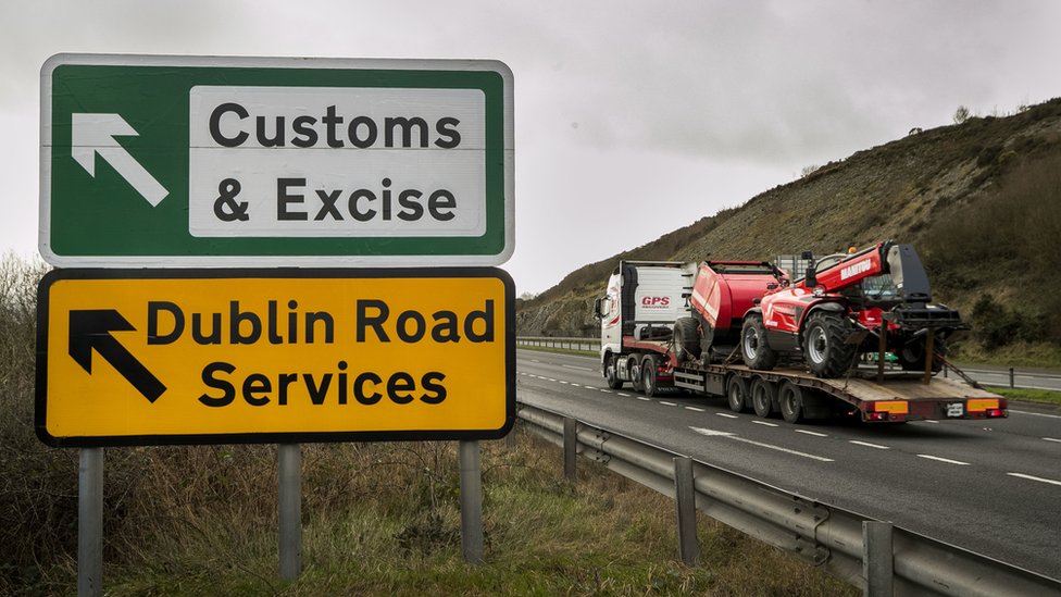 Грузовик проезжает мимо дорожных знаков возле ирландской границы