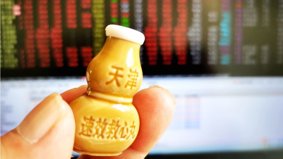 A shareholder checks the stock market with suxiao jiuxin pills (Medicine for the heart) in Qingdao, Shandong province, China, Oct 8, 2024