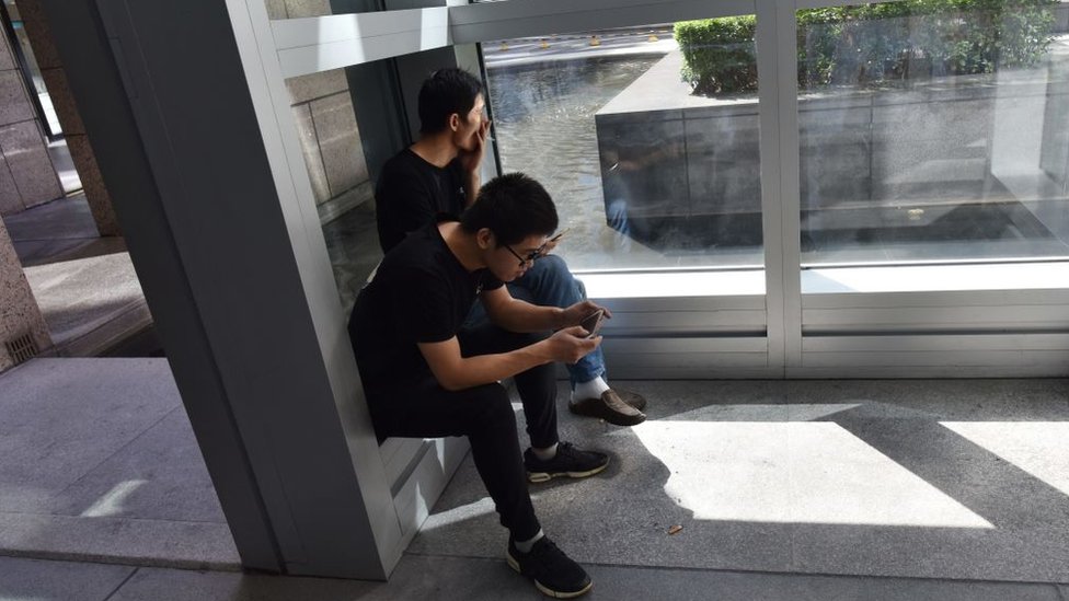 Según los trabajadores no fumadores de la firma japonesa Piala, cada uno de sus compañeros fumadores pierde 15 minutos en cada descanso para ir a fumar. Dos trabajadores en un área para fumadores.