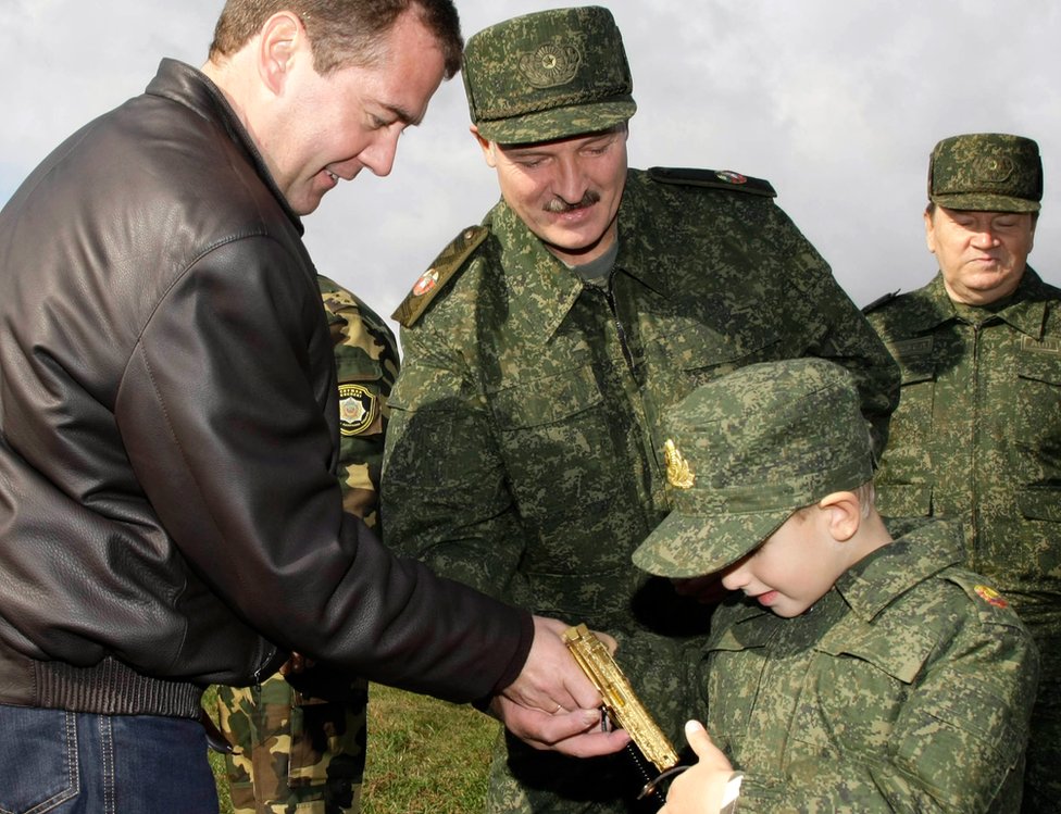 Президент России Дмитрий Медведев (слева) и его белорусский коллега Александр Лукашенко (в центре) взаимодействуют с пятилетним сыном Лукашенко Колей на Обуз-Лесновском полигоне недалеко от Барановичей в сентябре 2009 года
