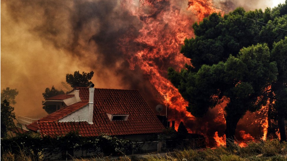 Una casa se ve envuelta entre llamas en Kineta, cerca de Atenas, el 23 de julio de 2018.