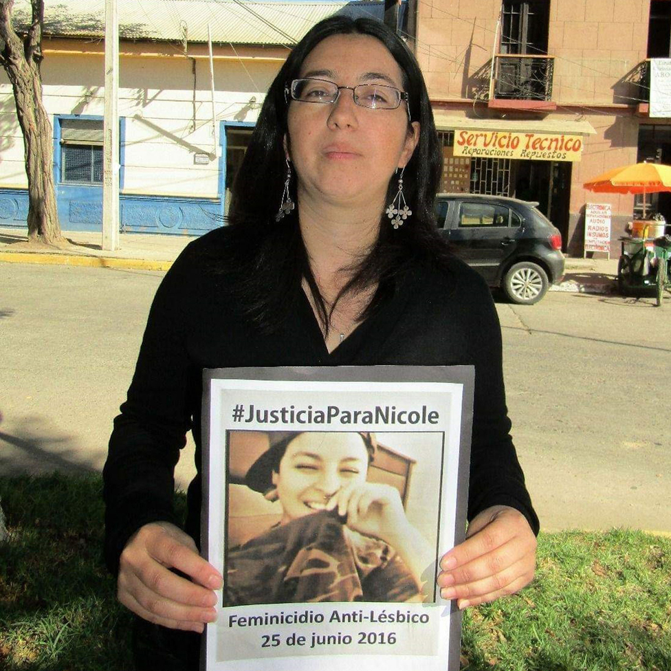 Двоюродная сестра Николь Сааведра Бахамондес, Мария, держит плакат с требованием справедливости для Николь