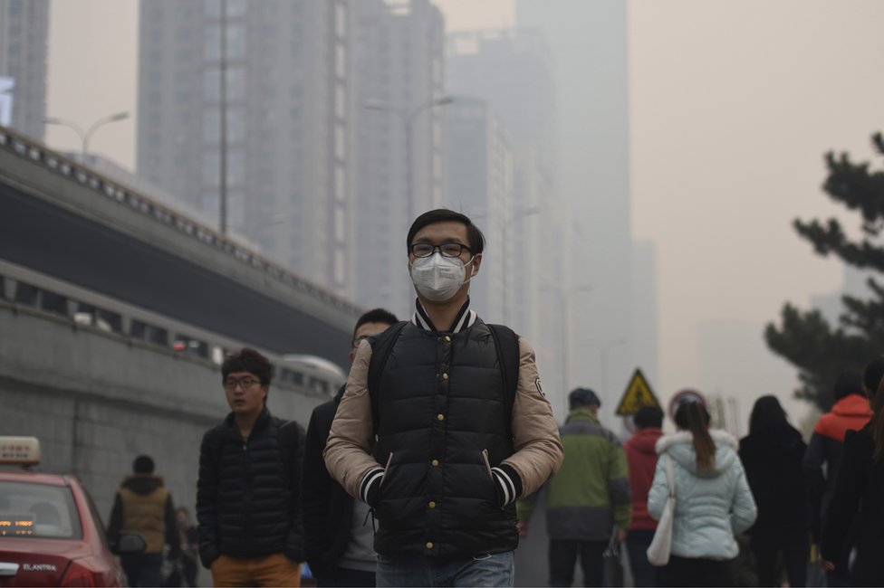 Мужчина в маске идет по улице в туманный день в Шэньяне, провинция Ляонин на северо-востоке Китая, понедельник, 9 ноября 2015 года.