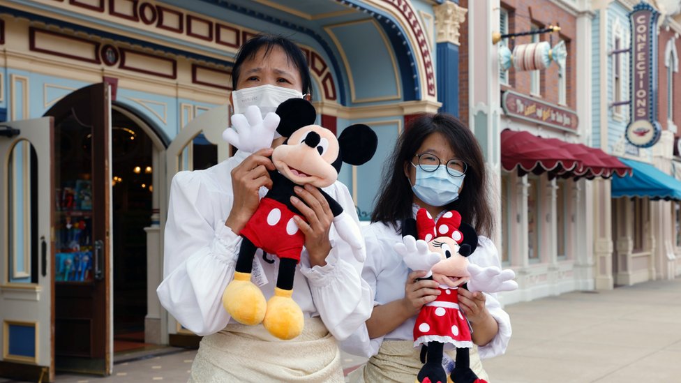 Staff members wearing face mask greet the guests during the reopening day of Disneyland to the public, after a second closure due to the coronavirus disease (COVID-19) outbreak, in Hong Kong, China, September 25, 2020.