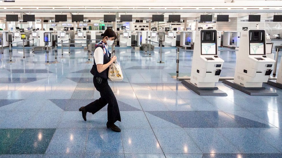 日本東京羽田機場一位工作人員走過已關閉的值機櫃台（22/5/2021）